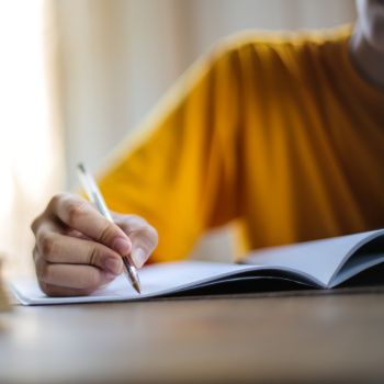 child in yellow shirt writing